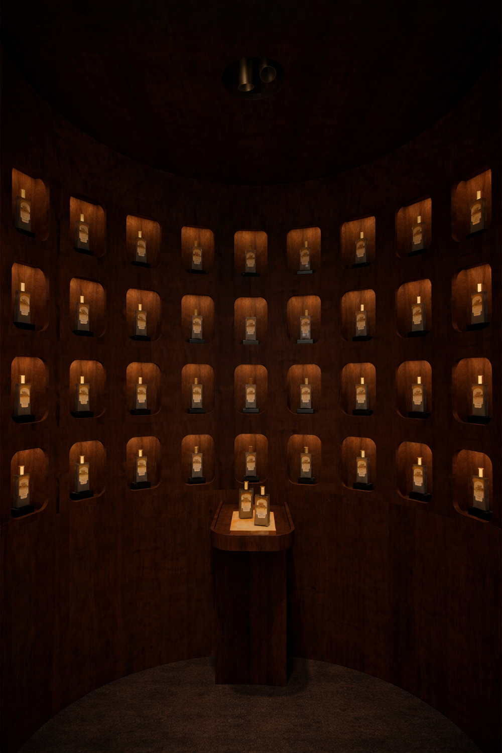 Rows of identical amber glass bottles, each containing a golden liquid and sealed with a white cap, are displayed in recessed wooden niches within a dimly lit circular room.